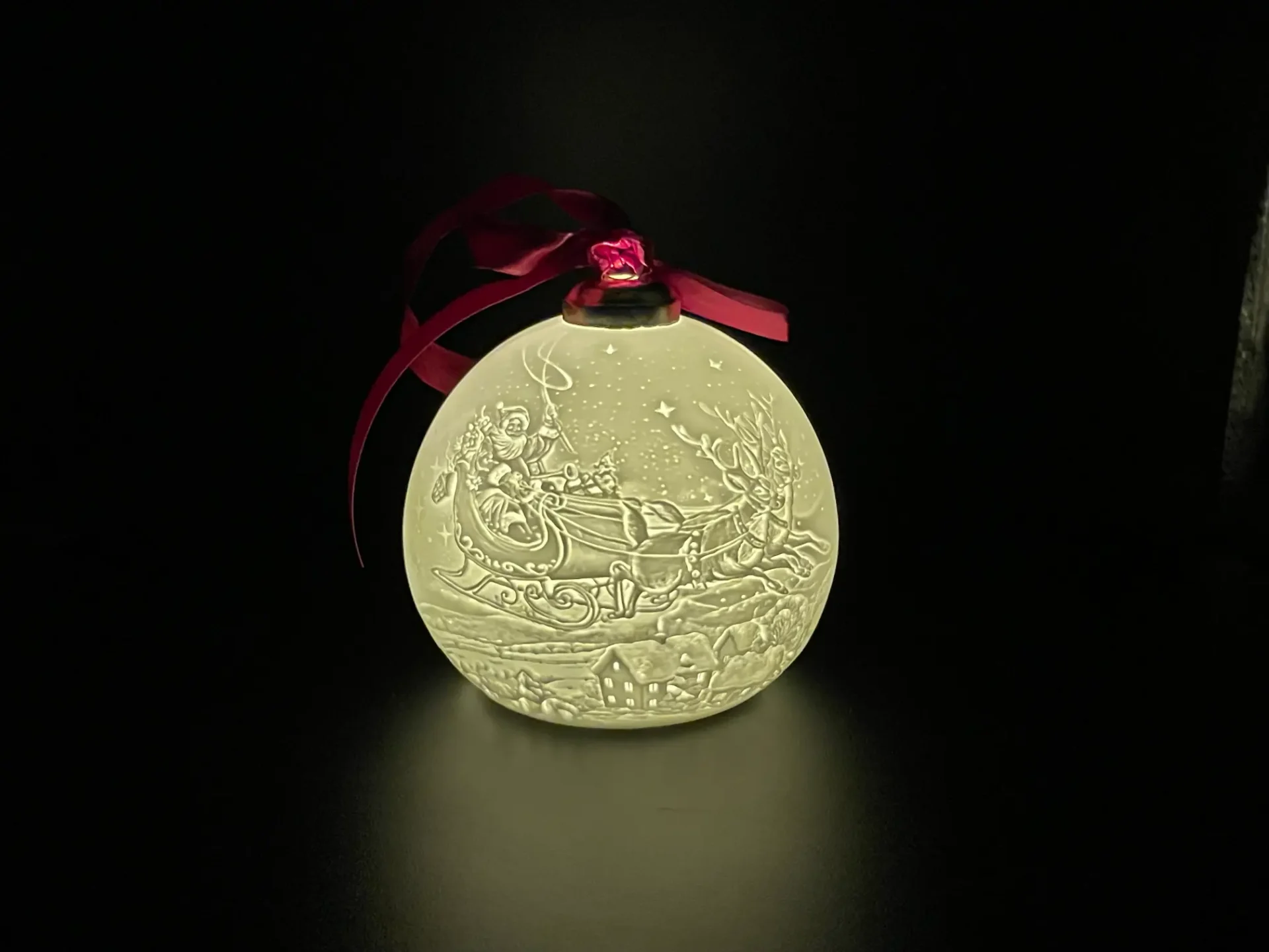 A christmas ornament with a red ribbon on it.